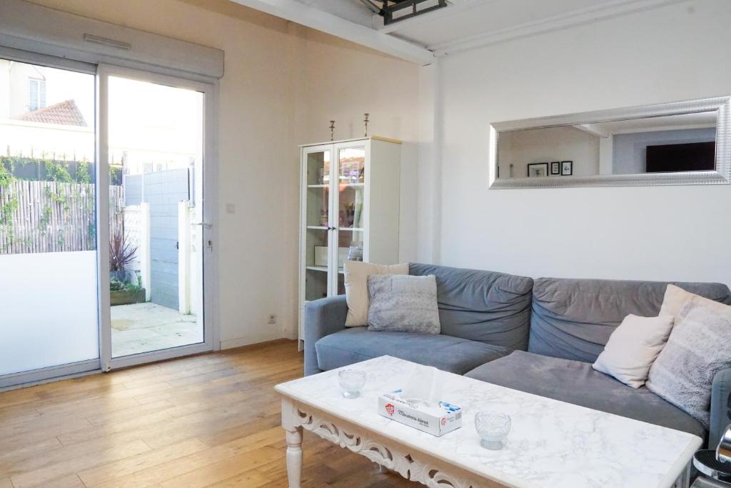 a living room with a couch and a coffee table at EXIGEHOME - Maison Cosy en plein centre de Versailles in Versailles