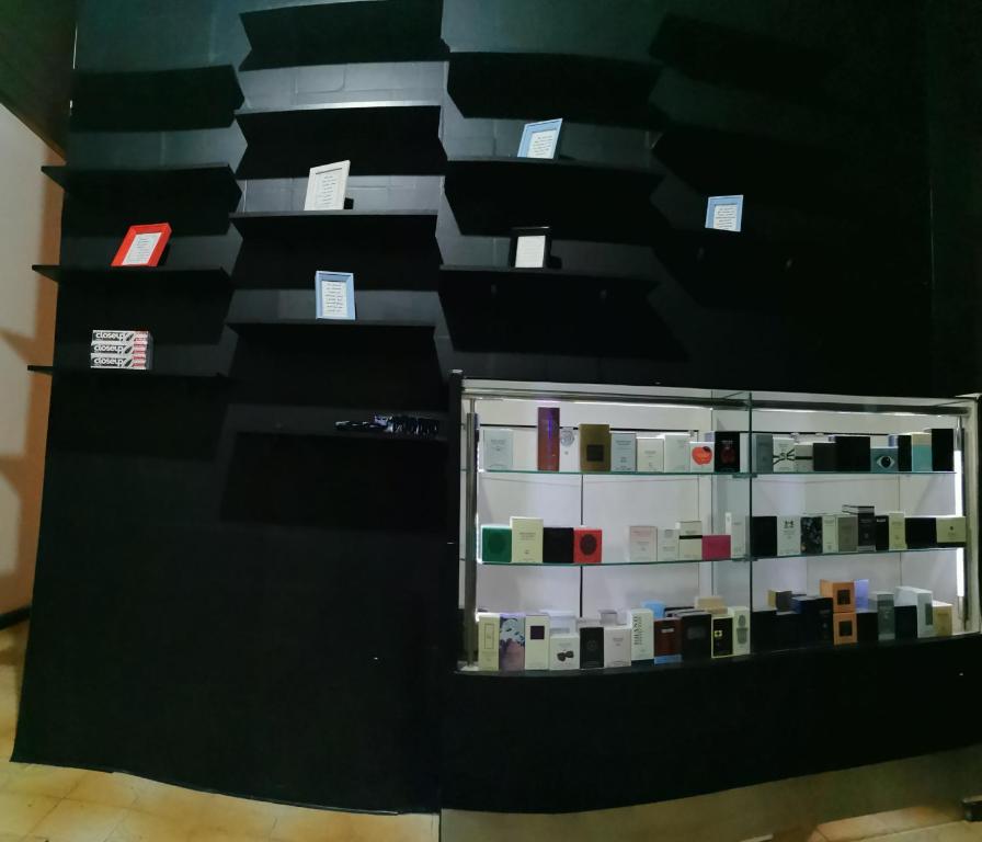 una pared negra con una estantería de cosméticos en Sos Hostel, en Camaçari