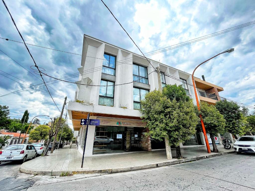 un edificio en una calle con coches aparcados delante en Don Francisco Apartamentos en Villa Carlos Paz