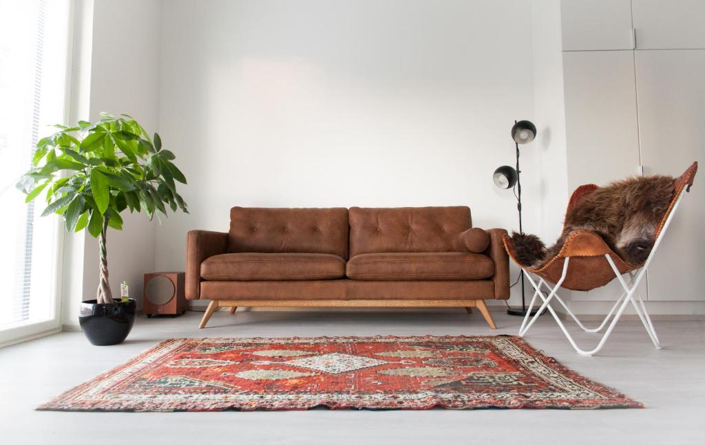 sala de estar con sofá marrón y silla en Boreal Corners, en Rovaniemi