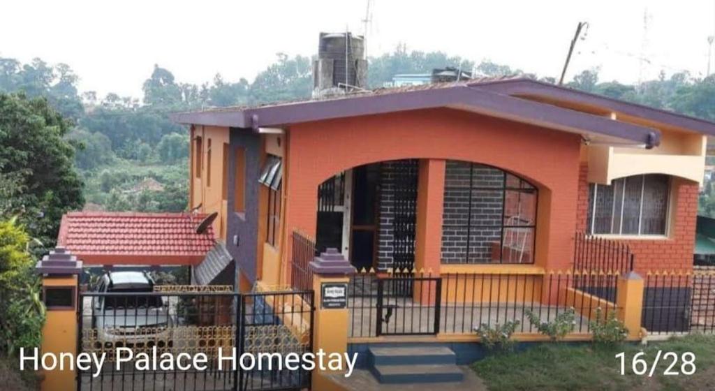 una piccola casa con una recinzione di fronte di Honey Palace Homestay a Madikeri