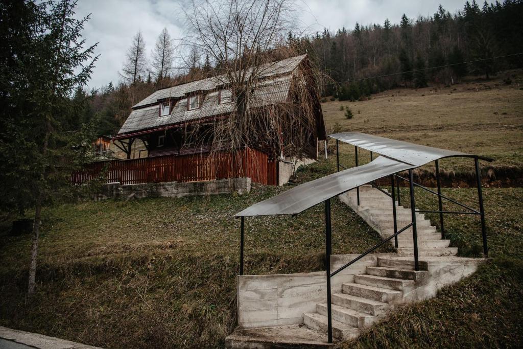 an old house with stairs in front of it at Cabana Yvan in Gîrda de Sus