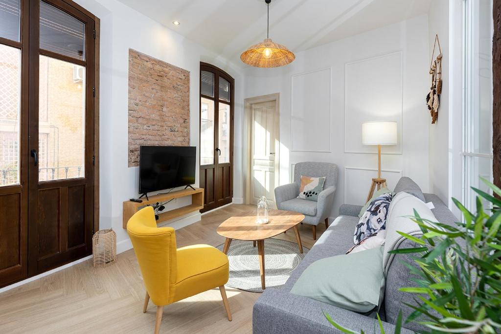 sala de estar con sofá y TV en Apartamentos PROGRESO, en Granada