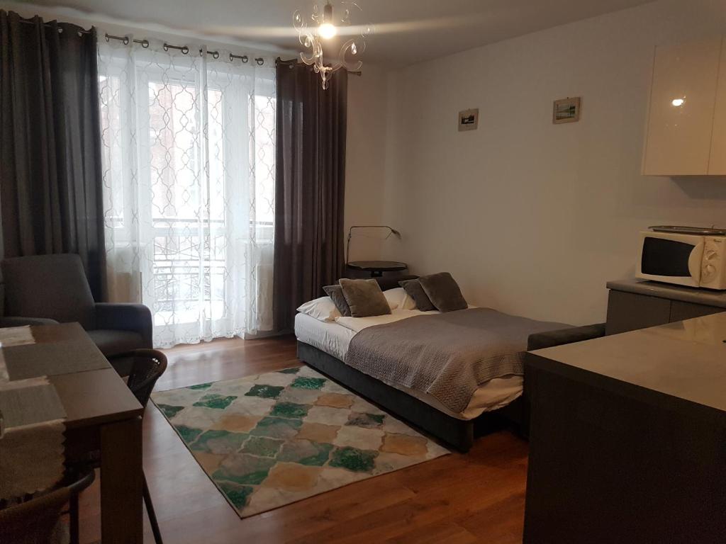 a bedroom with a bed and a living room at Apartament Elbląg Stare Miasto - Old Town in Elblag