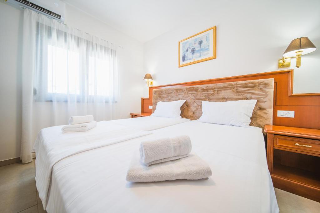 a bedroom with a large white bed with two towels on it at Pansion Lipa in Blato