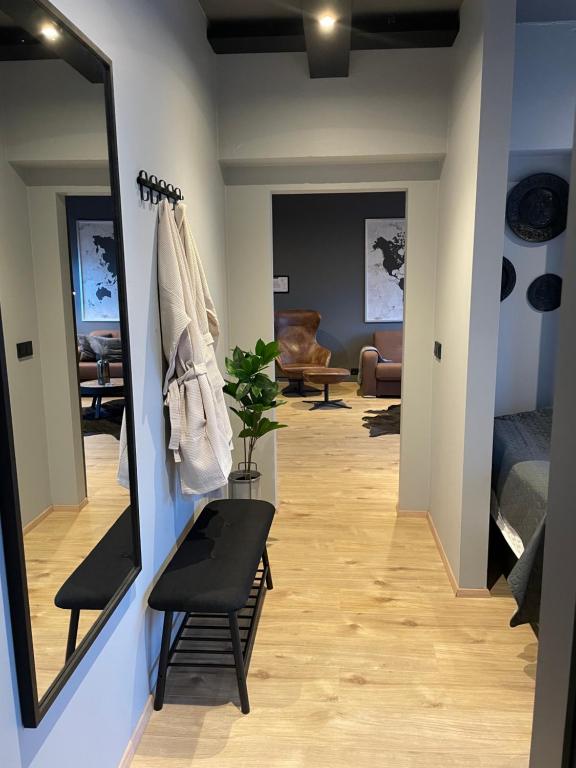 a hallway with a mirror and a chair and a couch at Lovely apartment with hot tub access in Akureyri