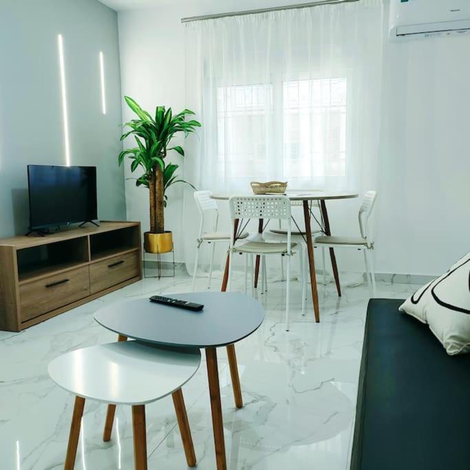 uma sala de estar com uma televisão e uma mesa e cadeiras em Dream Apartment Ioannina em Ioannina