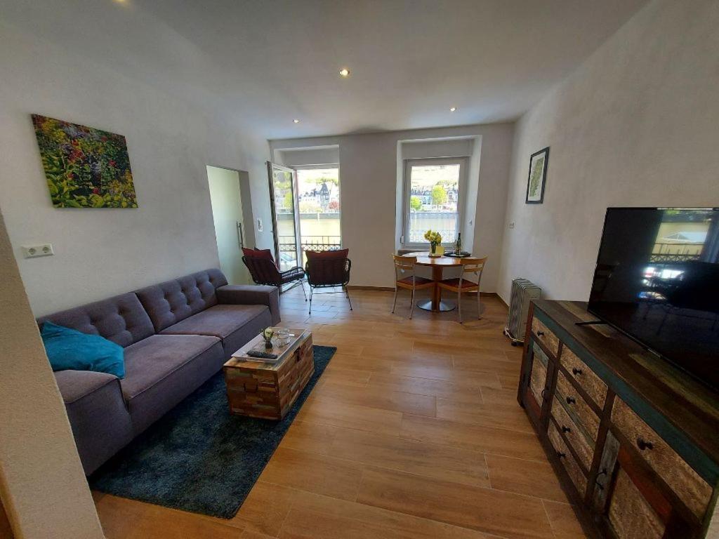 uma sala de estar com um sofá e uma televisão de ecrã plano em Moselliebe Zell em Zell an der Mosel