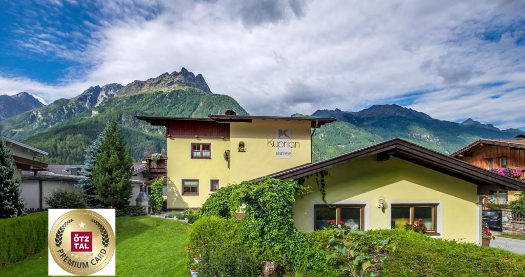 ein Haus mit einem Berg im Hintergrund in der Unterkunft Appartements Kuprian in Längenfeld