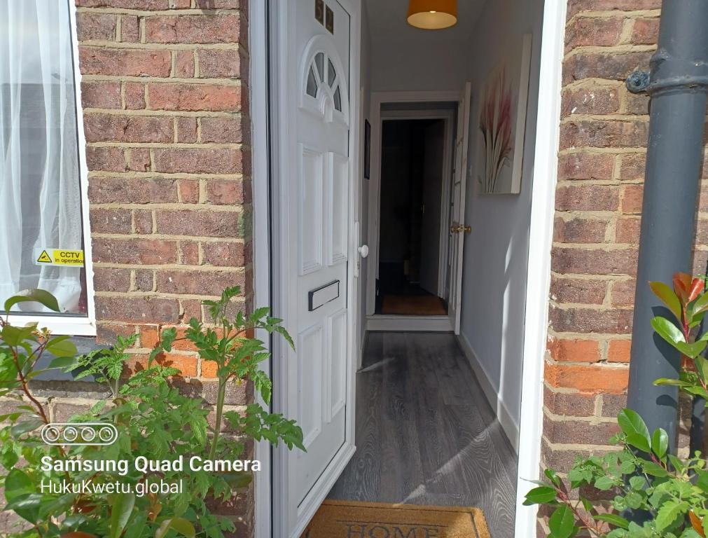 una puerta blanca que conduce a una casa de ladrillo en Salisbury House-Huku Kwetu Spacious 4 Bedrooms House- Sleeps 6 - Luton Town Centre, en Luton