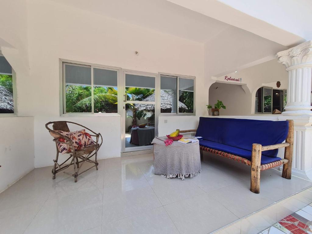 sala de estar con sofá azul y mesa en Ladha ya Zanzibar Boutique Guesthouse, en Jambiani
