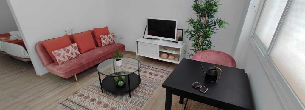 a living room with a red couch and a tv at Encantador estudio en Alameda de Hércules in Seville