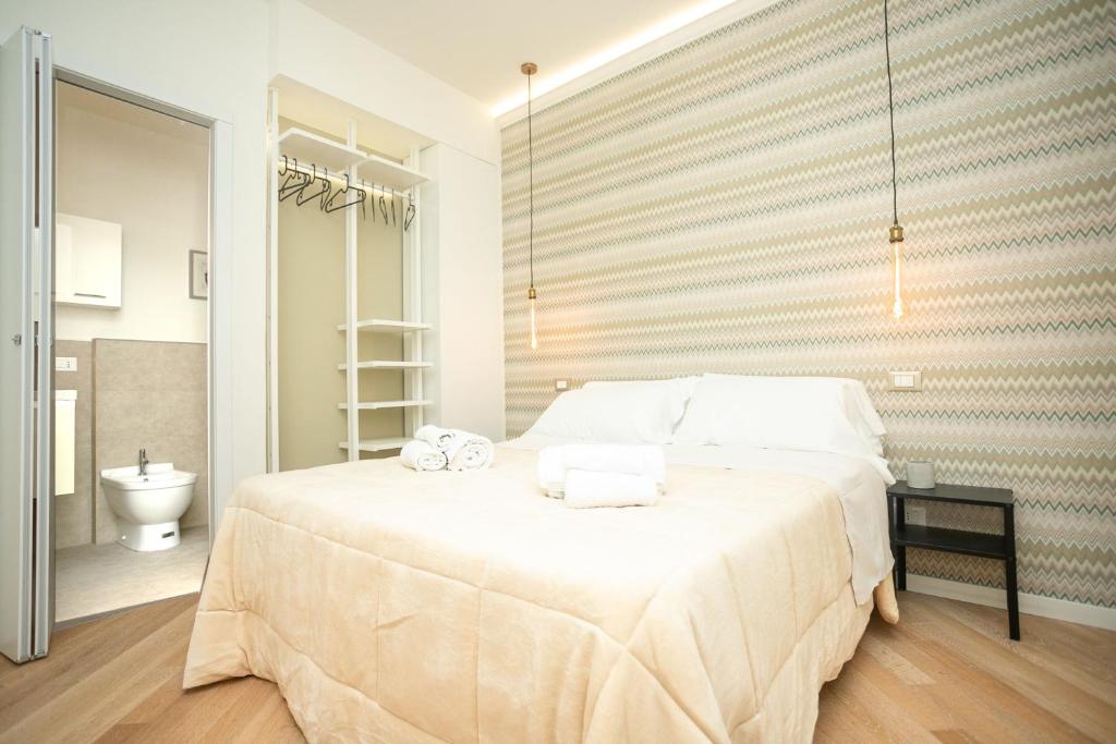 a bedroom with a large bed with towels on it at Modena Centro Junior Suite in Modena