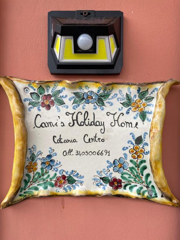 una cámara colgada en una pared con una almohada en Cami s holidays home, en Catania