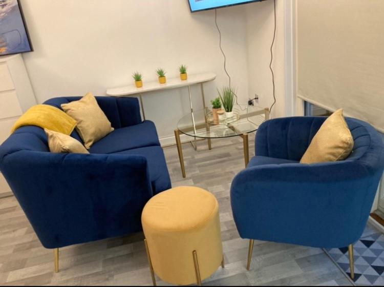 a living room with two blue chairs and a table at City of London in London