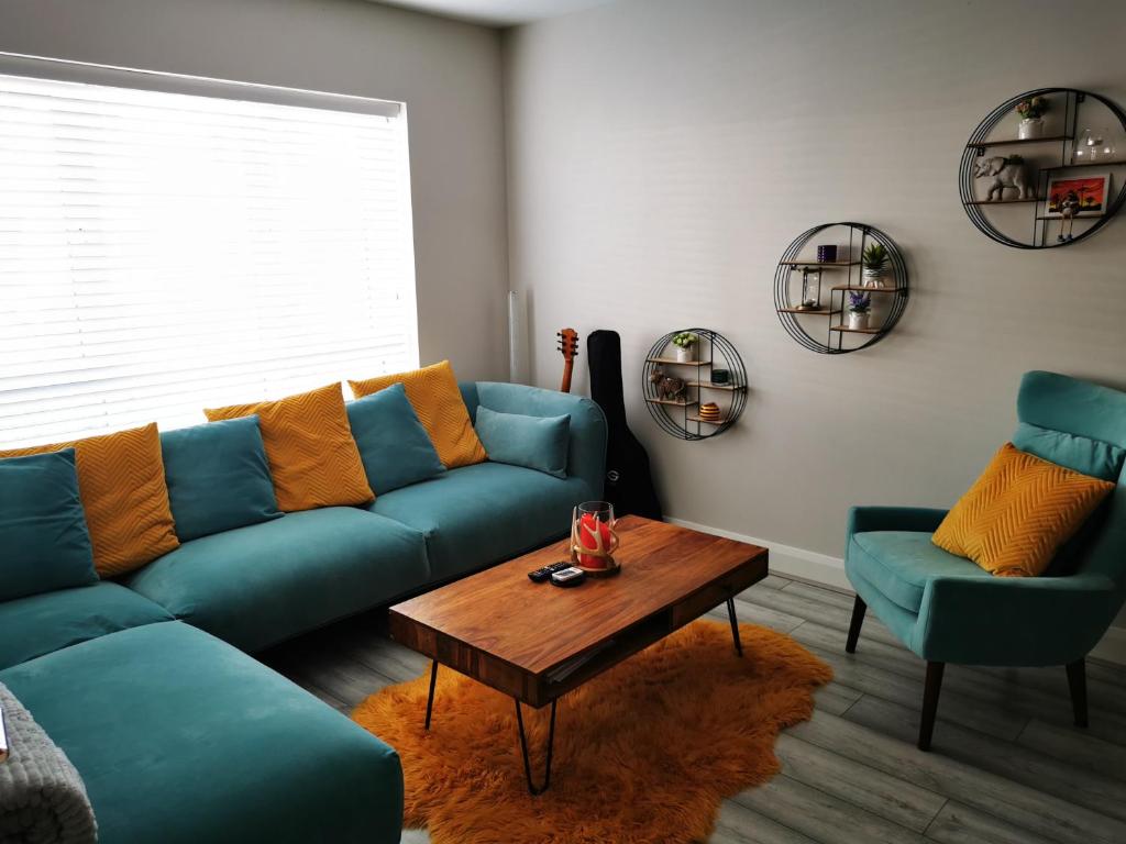 un soggiorno con divano blu e 2 sedie di Cozy room in Lucan a Lucan