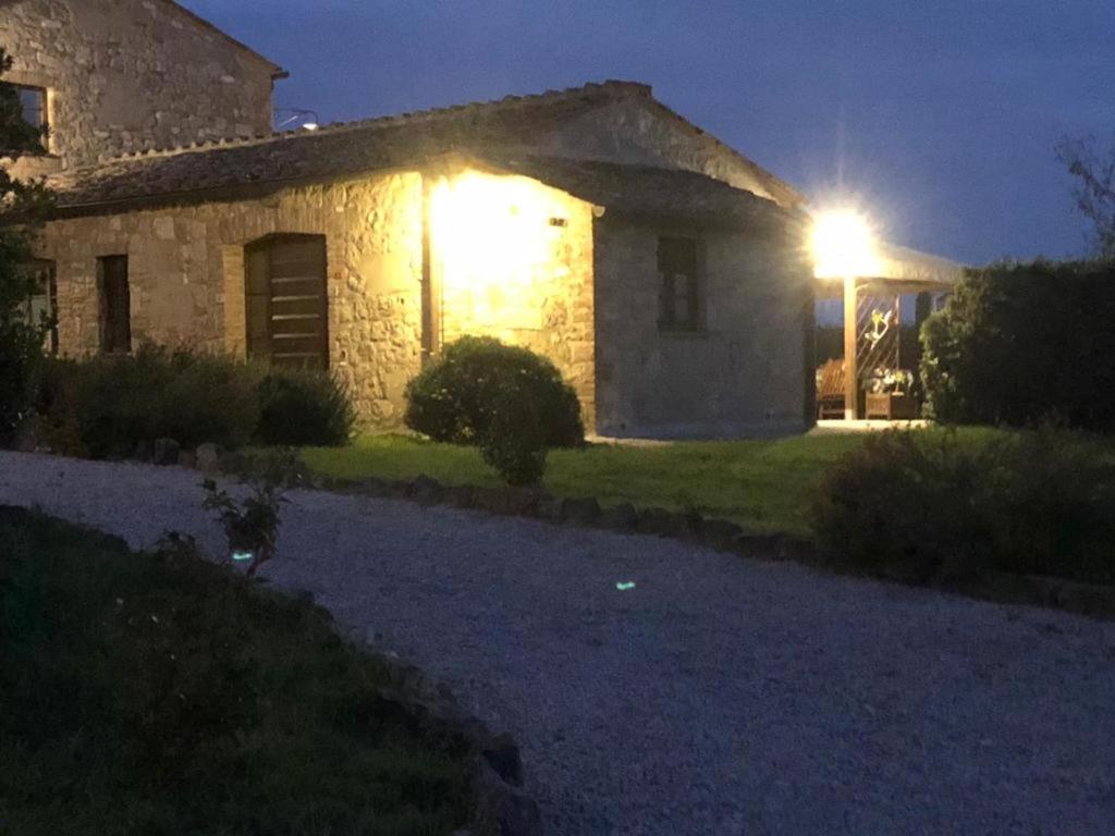 a stone house at night with the lights on at Country House Girasole Crete Senesi Vakantie Huis in Asciano