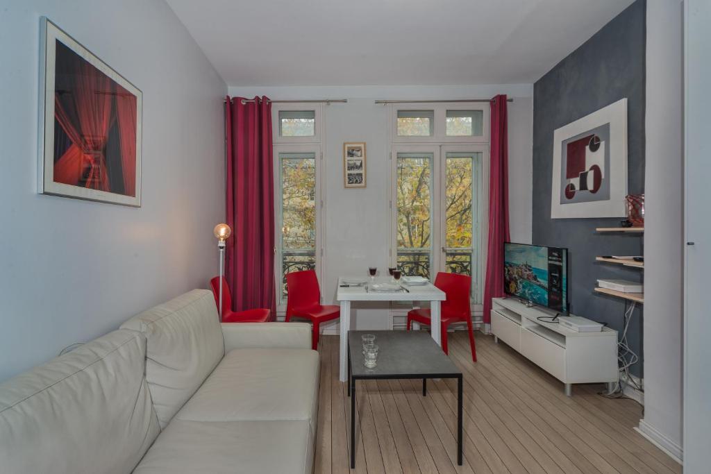 パリにあるSaint Michel Quartier Latinのリビングルーム(白いソファ、赤い椅子付)