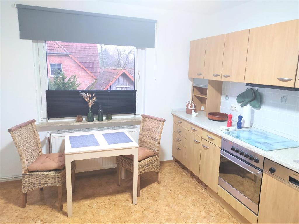 a kitchen with a table and chairs and a window at schöne geräumige ganze Wohnung als Unterkunft in Bergen