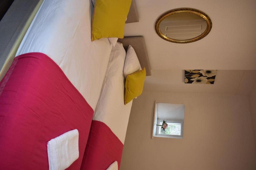 - une chambre dotée d'un grand lit avec des oreillers rouges et jaunes dans l'établissement Braillen Suite- 2 bedroom with kitchenette and bathroom, à Denbigh