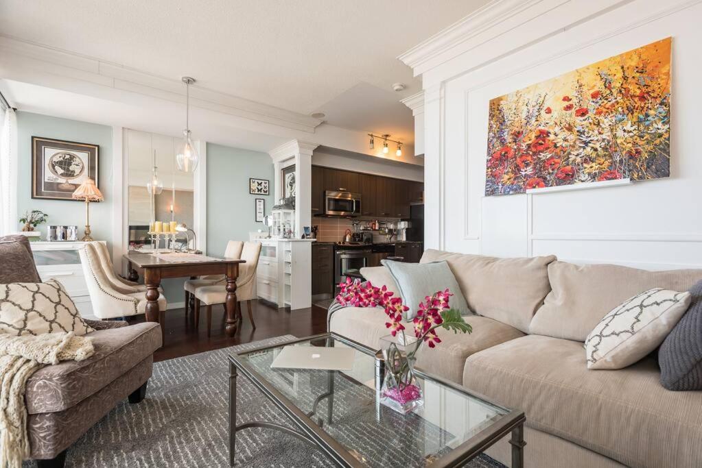 een woonkamer met een bank en een tafel met bloemen bij Stunning condo with fantastic view of the city! in Toronto