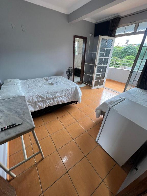 a bedroom with a bed and a tiled floor at Premium Center Hotel in Betim