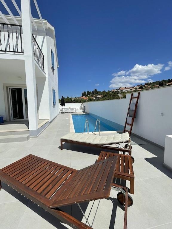 a patio with a bench and a chair on a building at Island Brac - Villa Vita in Nerežišće