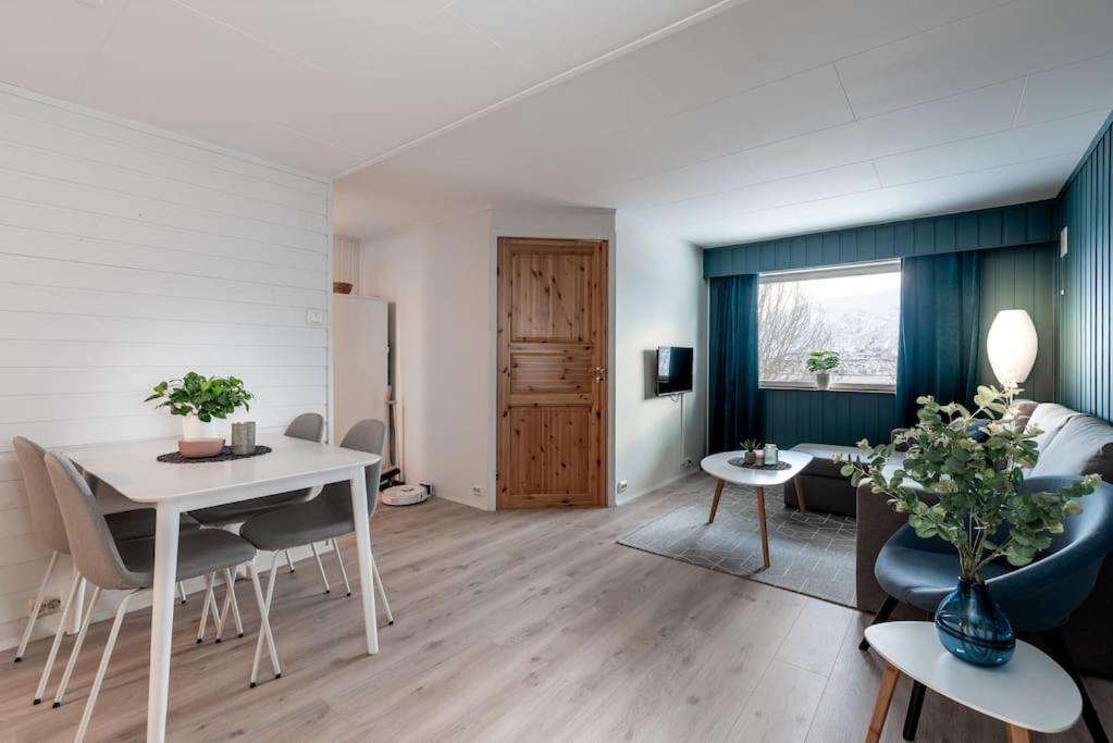 a living room with a white table and chairs at Modern apartment in the center of the island in Tromsø
