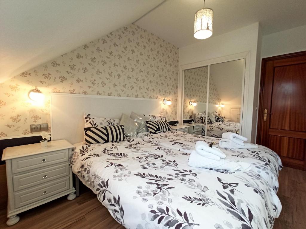 1 dormitorio con 1 cama grande con colcha blanca en Duplex con vistas al Picu Pienzu, Colunga, en Colunga