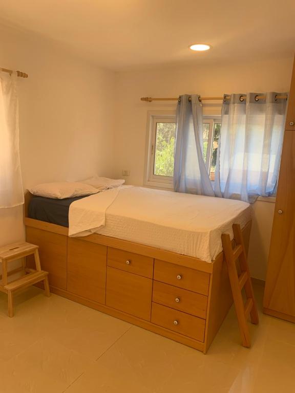 a bedroom with a large bed and a window at Iris privet room in Mevasseret Zion