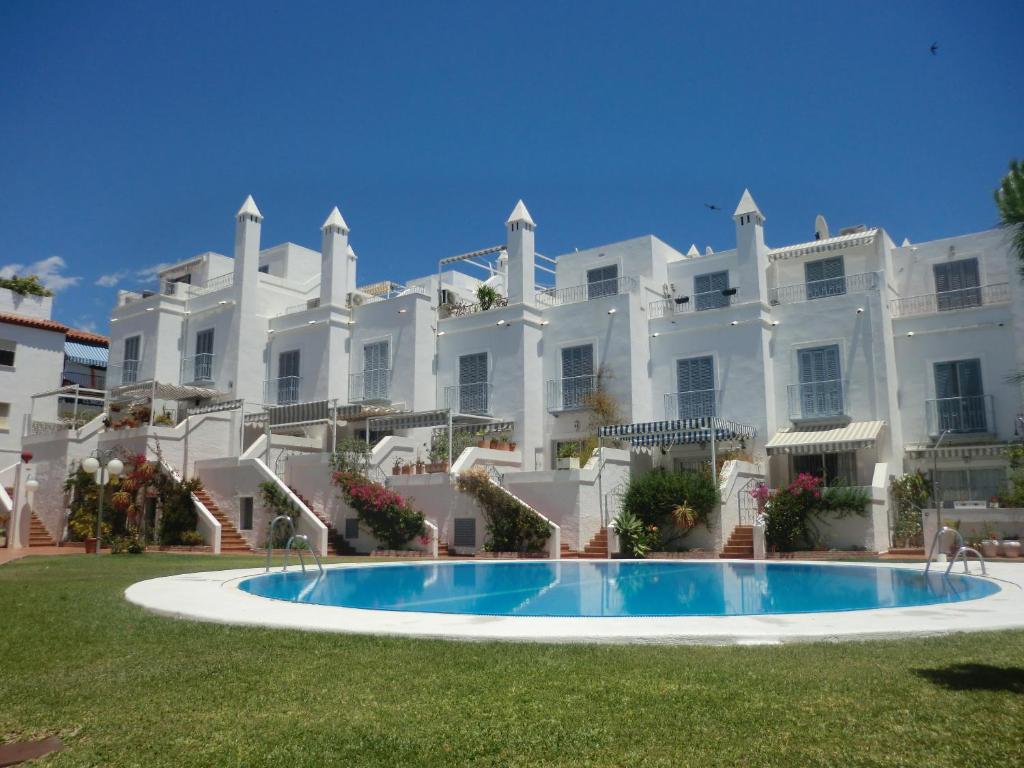 duży biały budynek z basenem przed nim w obiekcie Canovas Nerja - Casa adosada con piscina Los Huertos 6 w mieście Nerja
