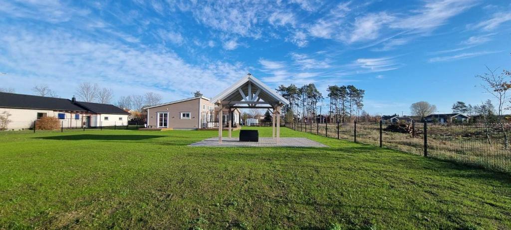 een huis met een tuinhuisje in het midden van een veld bij Trevlig fritidshus på Norra Öland in Löttorp