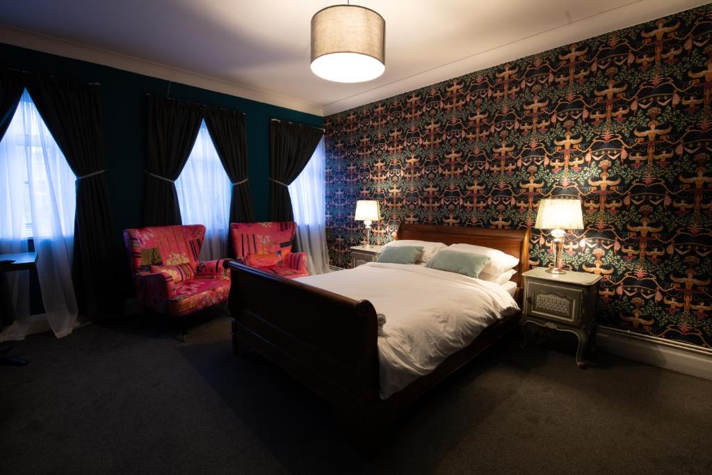 a bedroom with a large bed and a chair at The Angel of Bow in London
