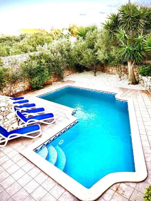 a swimming pool with two lounge chairs and a swimming pool at Ta’ Peppi Farmhouse in Qala