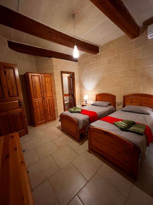 a bedroom with two beds in a room at Ta’ Peppi Farmhouse in Qala