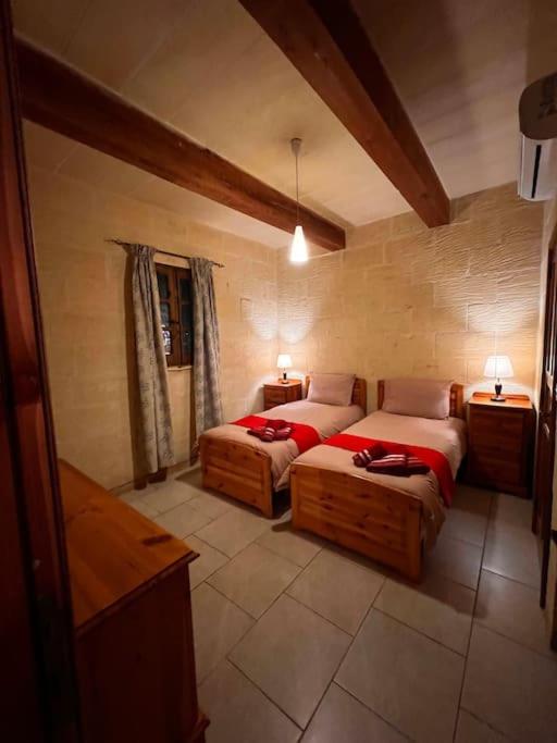 a bedroom with two beds in a room at Ta’ Peppi Farmhouse in Qala