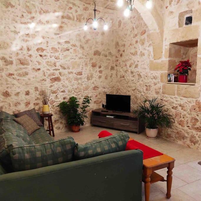 a living room with a couch and a tv at Ta’ Peppi Farmhouse in Qala