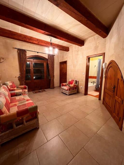 a large living room with a bed and a couch at Ta’ Peppi Farmhouse in Qala
