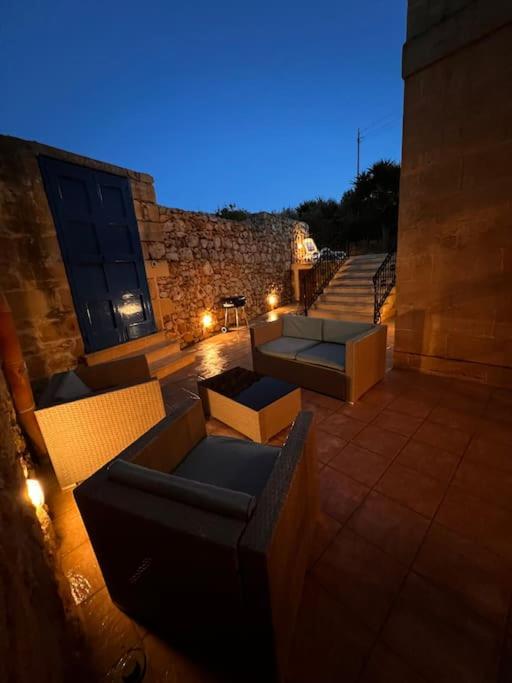 a rooftop patio with couches and stairs at night at Ta’ Peppi Farmhouse in Qala