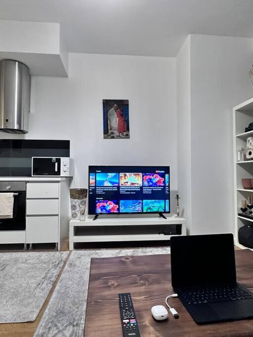 un salon avec une télévision et un ordinateur portable sur une table dans l'établissement Merkezi konumda şık daire, à Istanbul