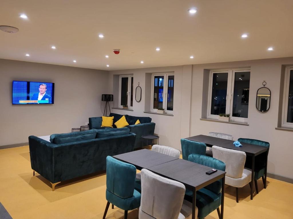 a living room with couches and tables and a tv at Phoenix Pods in Liverpool