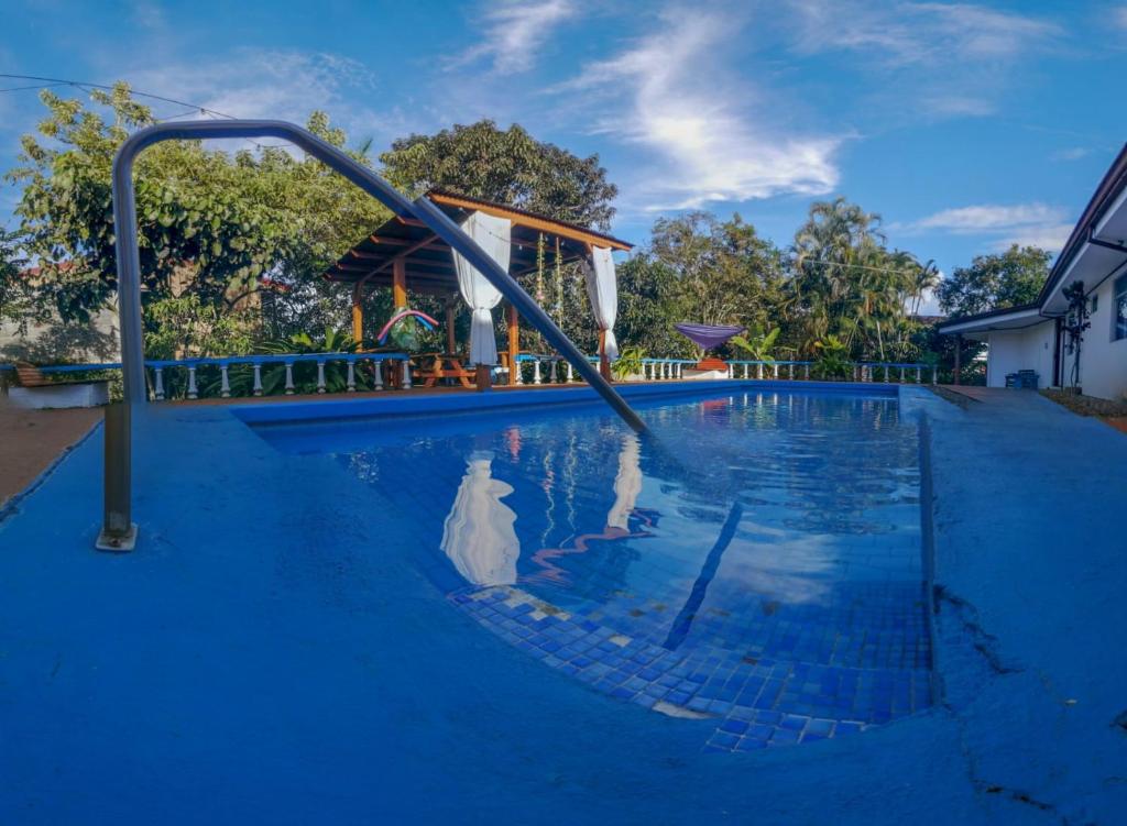 a swimming pool with a slide in the water at Hotel Geliwa in Turrialba