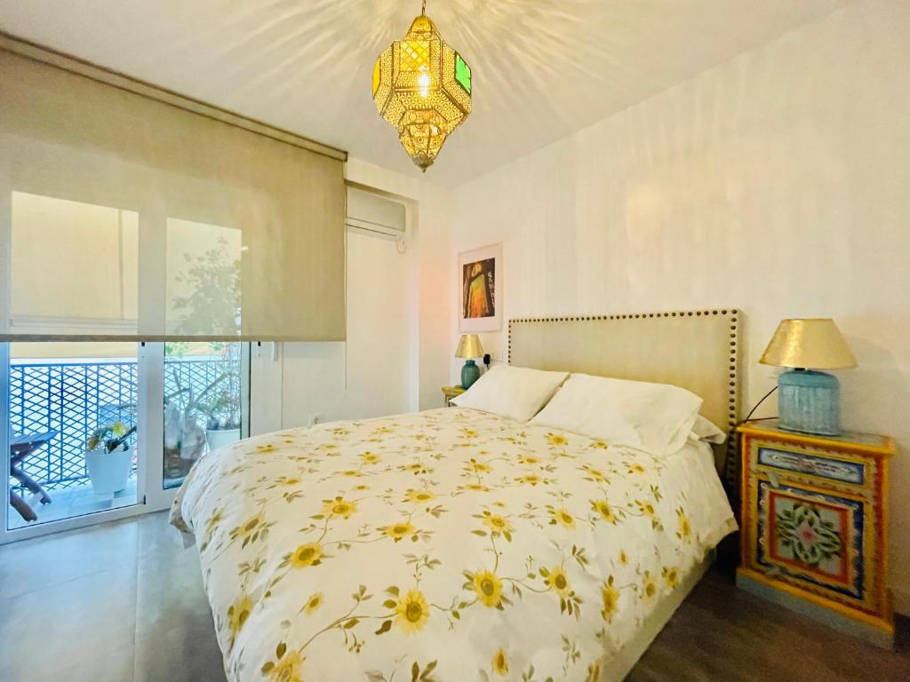 セビリアにあるApartamento Puerta Carmonaのベッドルーム1室(ベッド1台、シャンデリア付)