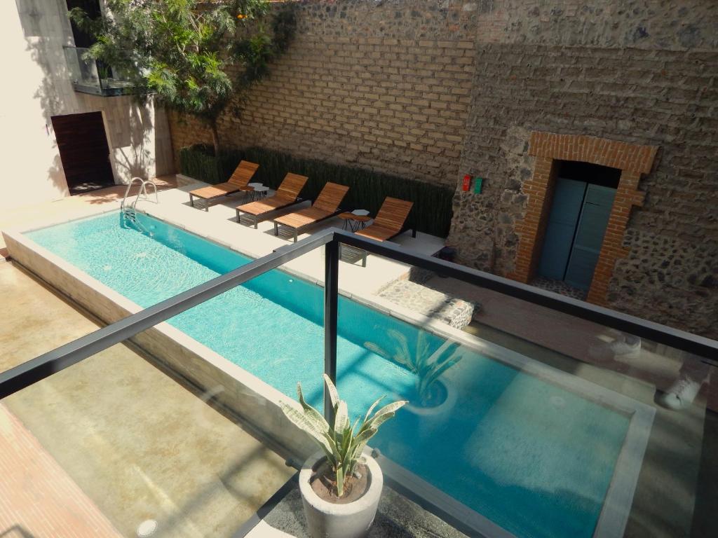 una piscina con sillas en un balcón con en Hotel Tila en Cholula