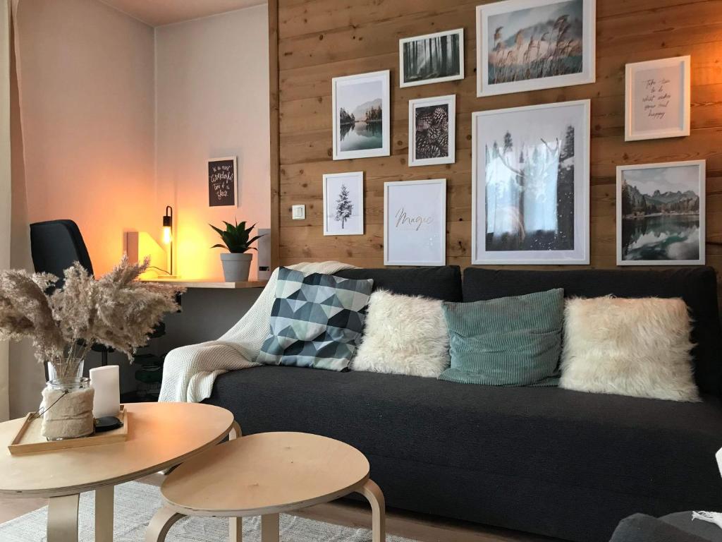 - un salon avec un canapé noir et une table dans l'établissement Appartement cosy T3 4 à 6 pers avec Piscines Intérieure, Extérieure & Sauna à Samoëns en Haute-Savoie, à Samoëns