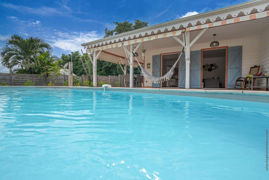 een groot blauw zwembad voor een huis bij Villa Surelles - 3 chambres - piscine - Le Diamant in Le Diamant