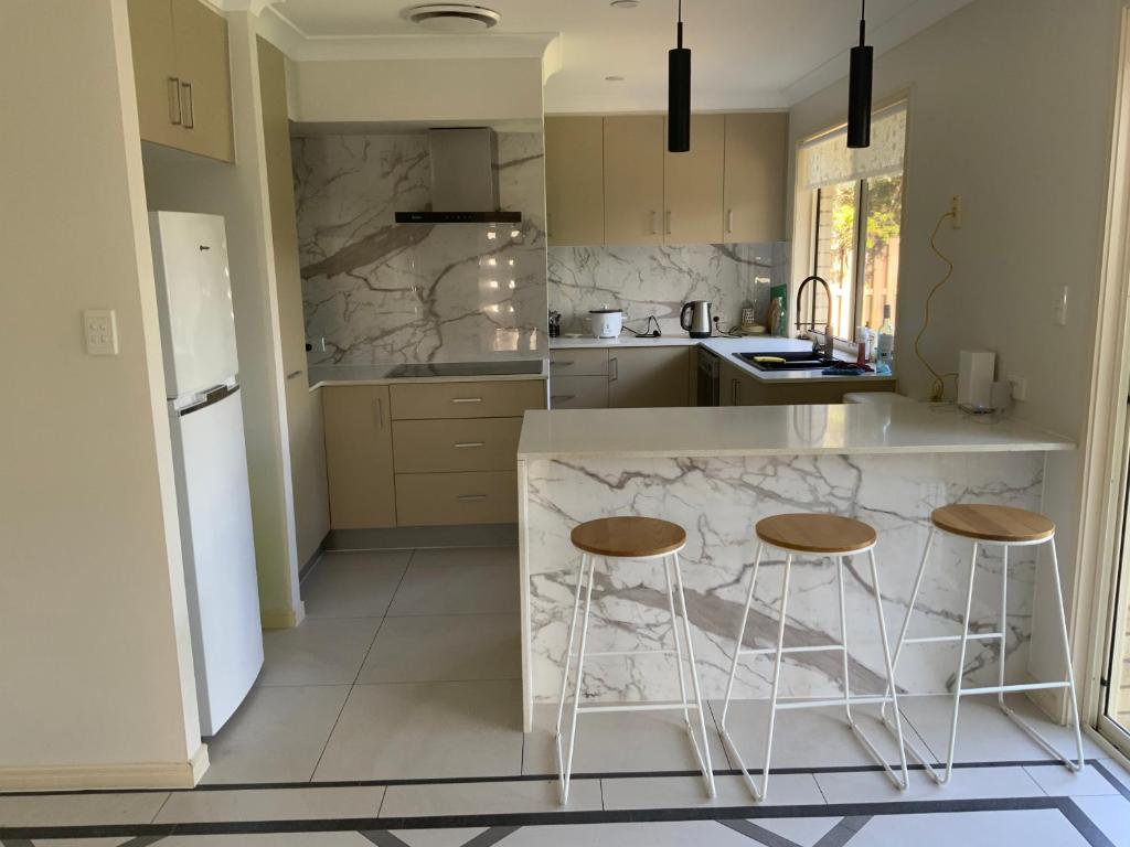 a kitchen with a marble counter and two stools at Shared house with other guests near shopping center and theme parks in Gold Coast