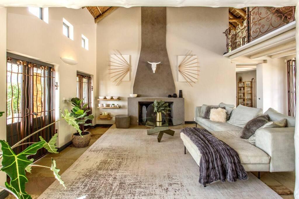 a living room with a couch and a fireplace at Exquisite, Artsy ArtepHouse in Cape Town