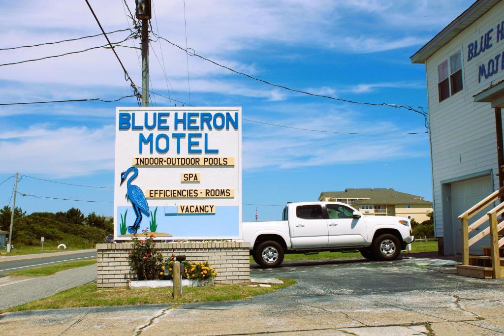 un camión estacionado al lado de un cartel de un motel Heron azul en Blue Heron Motel en Nags Head