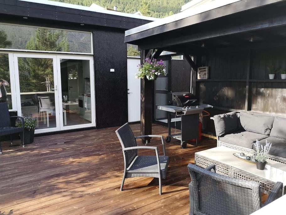 a patio with a couch and chairs on a deck at Gjestehus i Sogndal in Sogndal